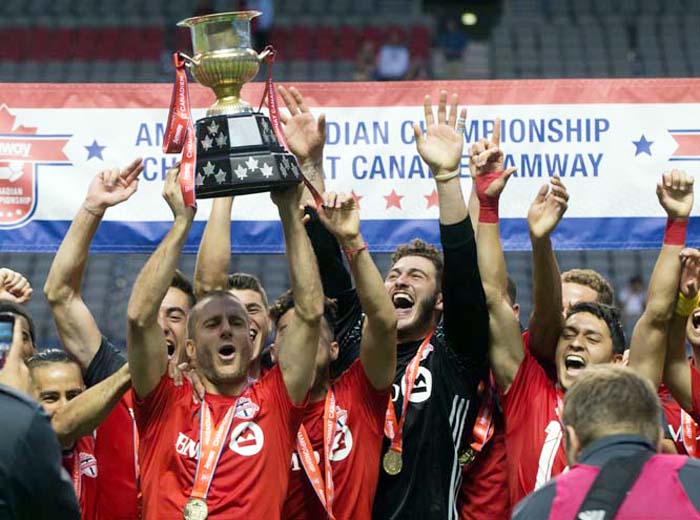 Toronto FC's Benoit Cheyrou (left) and his teammates celebrate with the trophy after defeating the Vancouver Whitecaps on aggregate, following the second leg of the Canadian Championship soccer final on Wednesday in Vancouver, British Columbia.