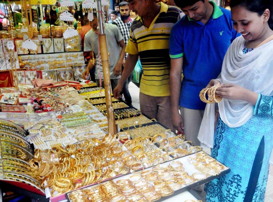 Buyers making their choice to imitation ornaments at a shop in the city's Gausia Market ahead of Eid-ul-Fitr. The snap was taken on Monday.