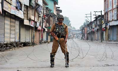 An Indian paramilitary troop stand during a curfew in Srinagar on Sunday.