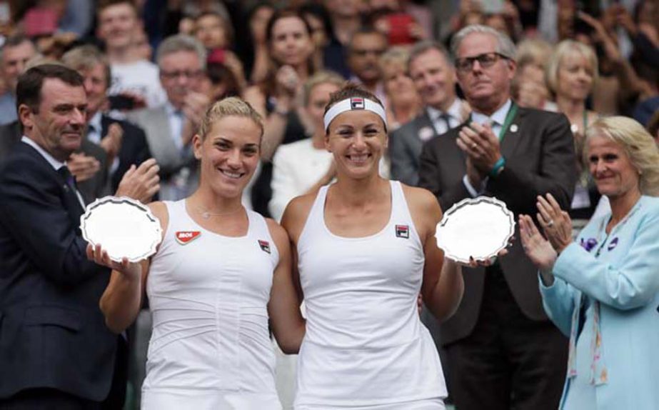 Timea Babos of Hungary (left) and Yaroslava Shvedova of Kazahkstan hold their runner's up trophies after losing the women's doubles final against Venus and Serena Williams of the U.S on day thirteen of the Wimbledon Tennis Championships in London on Sat