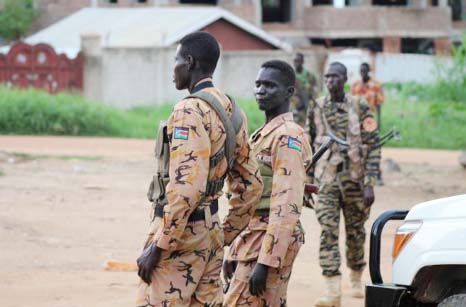South Sudanese policemen and soldiers stand guard along a street following renewed fighting in South Sudan's capital Juba.