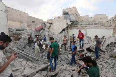 Men look for survivors under the rubble of a damaged building after an airstrike on Aleppo's rebel held Kadi Askar area in Syria