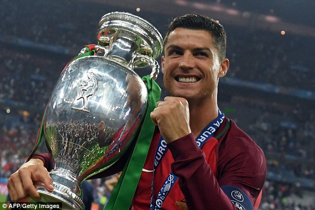 Portugal's forward Cristiano Ronaldo smiles while posing with the trophy after winning the Euro 2016 final on Sunday night.