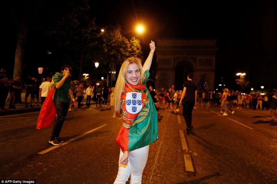 A Portugal supporter celebrates her country's victory near the Arc de Triomphe after the Euro 2016 final in Paris on Sunday.