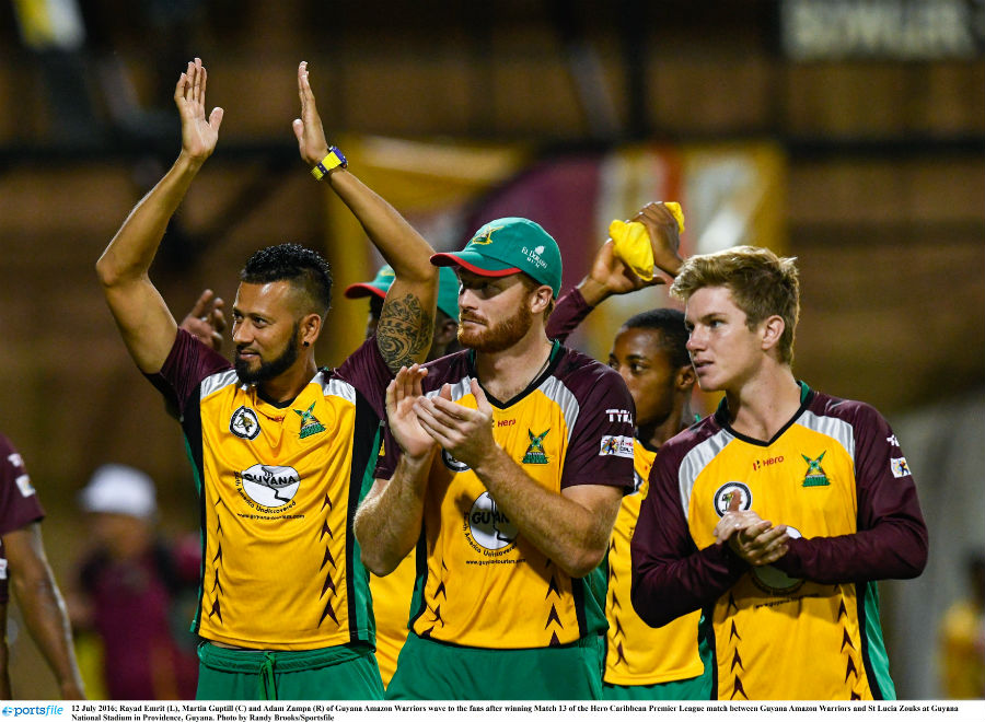 Rayad Emrit (L), Martin Guptill (M) and Adam Zampa (R) acknowledge the cheer of the crowd during the CPL match between Guyana Amazon Warriors and St Lucia Zouks in Guyana on Tuesday.