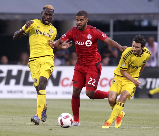 Toronto FC forward Jordan Hamilton (center) works between Columbus Crew midfielder Tony Tchani (left) and defender Michael Parkhurst during the second half of an MLS soccer match in Columbus, Ohio on Wednesday. The match ended in a 1-1 draw.