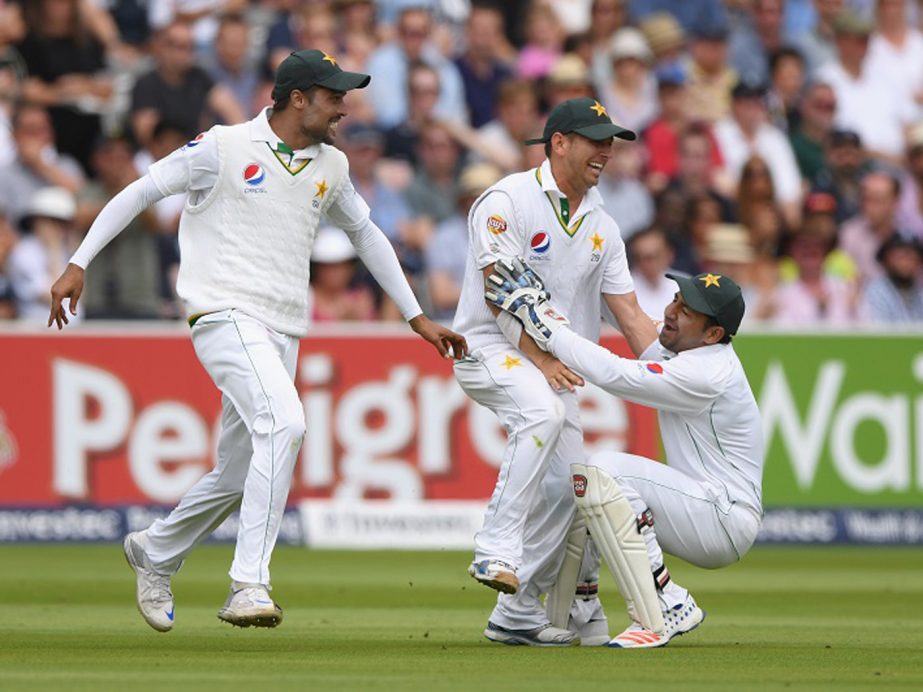 Pakistan fielder Yasir Shah (c) is congratulated by wicketkeeper Sarfraz Ahmed (r) and Mohammad Amir after catching Joe Root during day four of the 1st Investec Test match between England and Pakistan at Lord's Cricket Ground in London, England on Sund