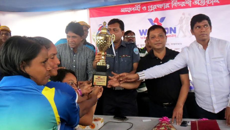 Police Super of Cox's Bazar district Shyamal Kumar Nath handing over the championship trophy to the players of Khelaghor Samaj Kalyan Sangha, which became champions in the Women's Division of the Walton First Beach Throwball Competition at the Laboni Po