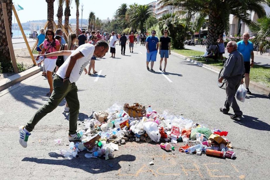 A man spits at the site in Nice where attacker Mohamed Lahouaiej-Bouhlel was killed by police after killing scores of people by driving a truck through crowds.