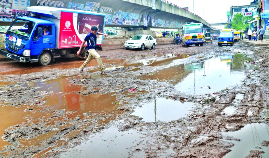 The main throughfare underneath Jatrabari Flyover is in appalling situation where potholes and muddy waters creating obstacles to movement of vehicles and pedestrians. Authorities concerned did not pay any heed to repair it. This photo was taken on Tuesd