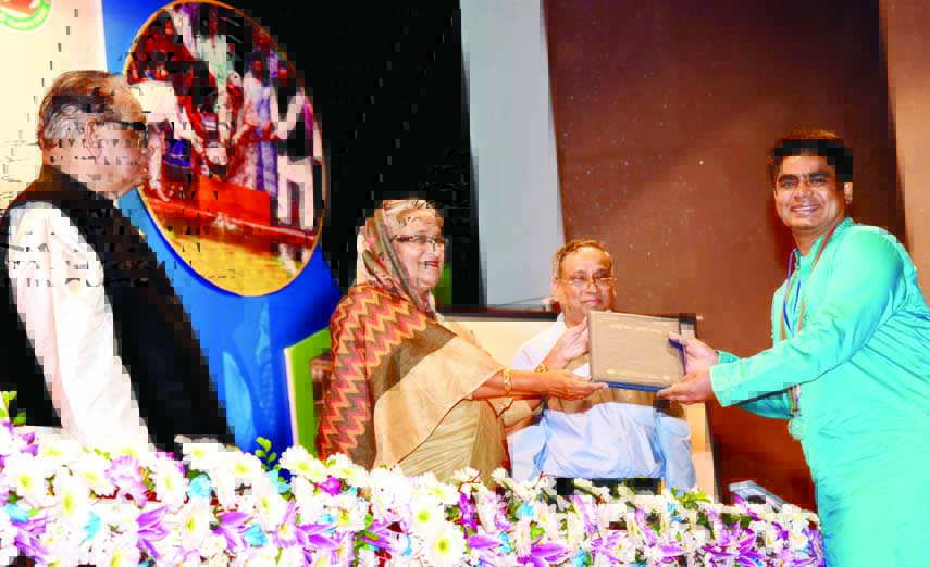 Prime Minister Sheikh Hasina handing over award to a recipient for his contribution in fisheries sector at the inauguration of National Fisheries Week-2016 in the auditorium of Farmgate Krishibid Institution in the city on Wednesday. BSS photo