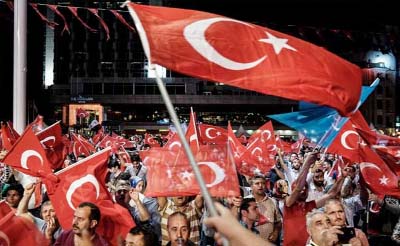 Pro-government supporters wave a Turkish flag as they protest on Istanbul's iconic Bosporus Bridge, late Thursday.