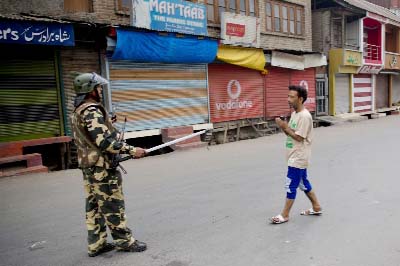 An Indian Paramilitary soldier stops a Kashmiri Muslim man in Srinagar, Indian controlled Kashmir on Friday.