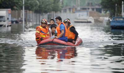 Rescuers use a raft to transport people along a flooded street in Shenyang in northeastern China's Liaoning Province.