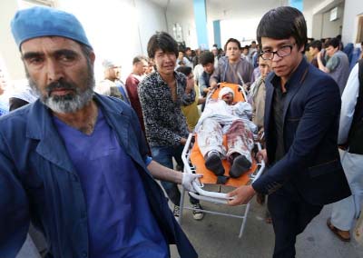 Afghans help a man who was injured in a deadly explosion that struck a protest march by ethnic Hazaras, at a hospital in Kabul, Afghanistan on Saturday.