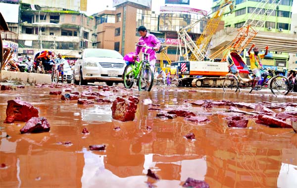 Several potholes and craters developed due to rains on the main thoroughfare near Mouchak where fly-over work in progressing at a snail's pace causing sufferings to movement of vehicles and pedestrians. This photo was taken on Sunday.