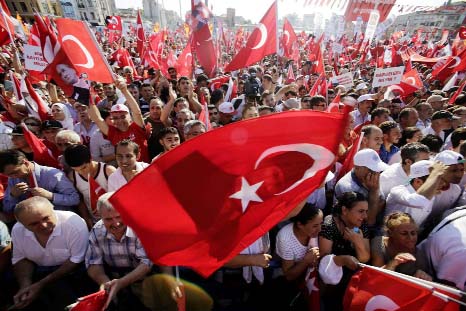 Demostrators hold giant Turkish national flag at Istanbul's Taksim Square on Sunday during a cross-party rally.