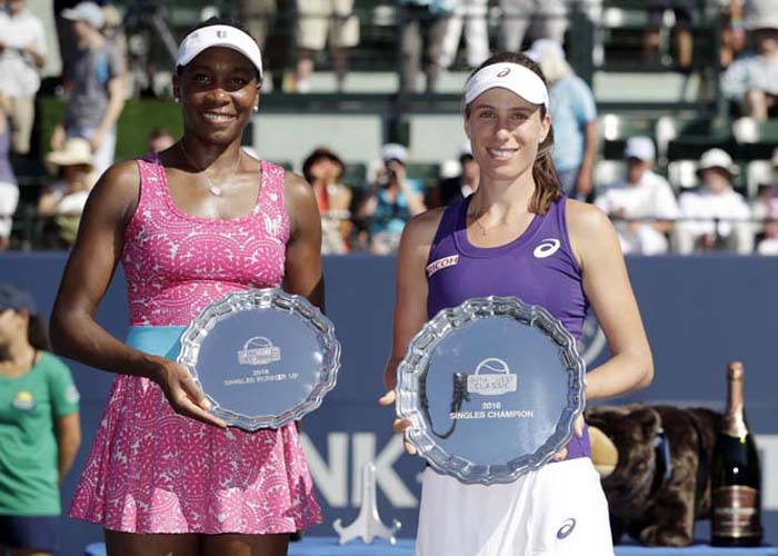 Johanna Konta, right, of Britain, holds the winner's plate next to Venus Williams, of the United States, with the runner-up plate, after the final in the Bank of the West Classic tennis tournament in Stanford, Calif on Sunday. Konta won 7-5, 5-7, 6-2.