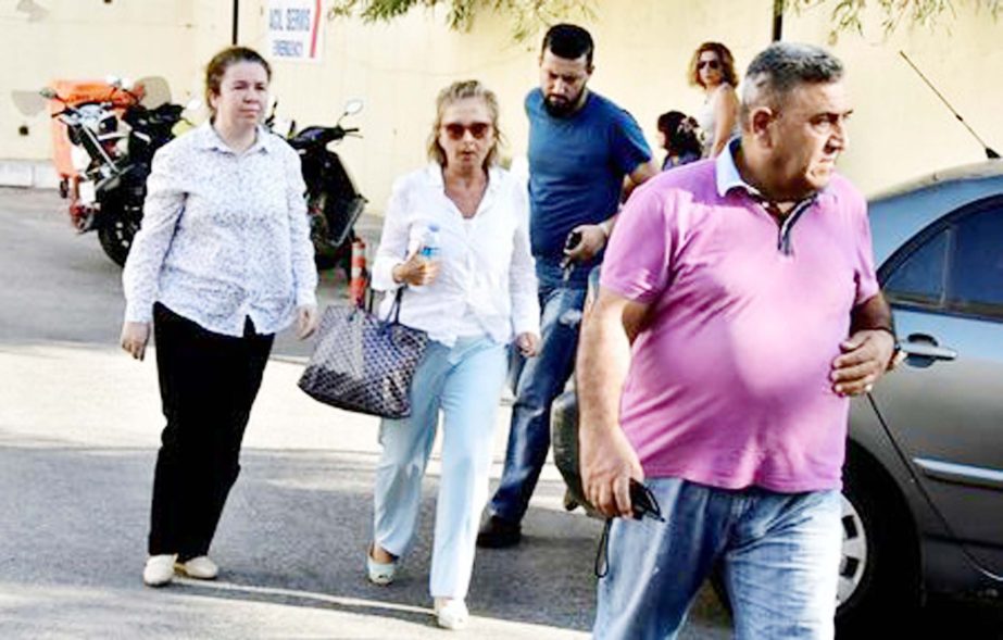 Turkish journalist Nazli Ilicak (C), also a well-known commentator and former parliamentarian, is escorted by a police officer (R) and her relatives (L and rear) after being detained and brought to a hospital for a medical check in Bodrum, Turkey.