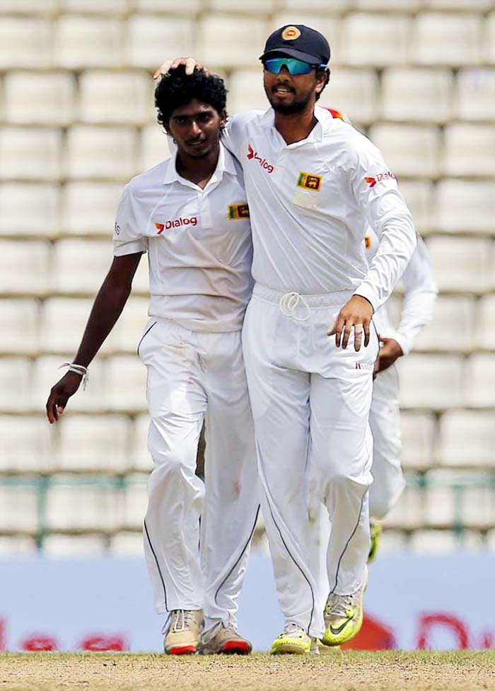 Sri Lanka's cricketer Dinesh Chandimal congratulates bowler Lakshan Sandakan for the dismissal of Australia's Steve O' Keefe during day two of the first Test cricket match between Sri Lanka and Australia in Pallekele, Sri Lanka on Wednesday.