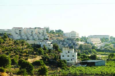 Photo shows a house (in the foreground) belonging to Palestinians in front of buildings in the Kiryat Arba Jewish settlement on the outskirts of the Palestinian flashpoint city.