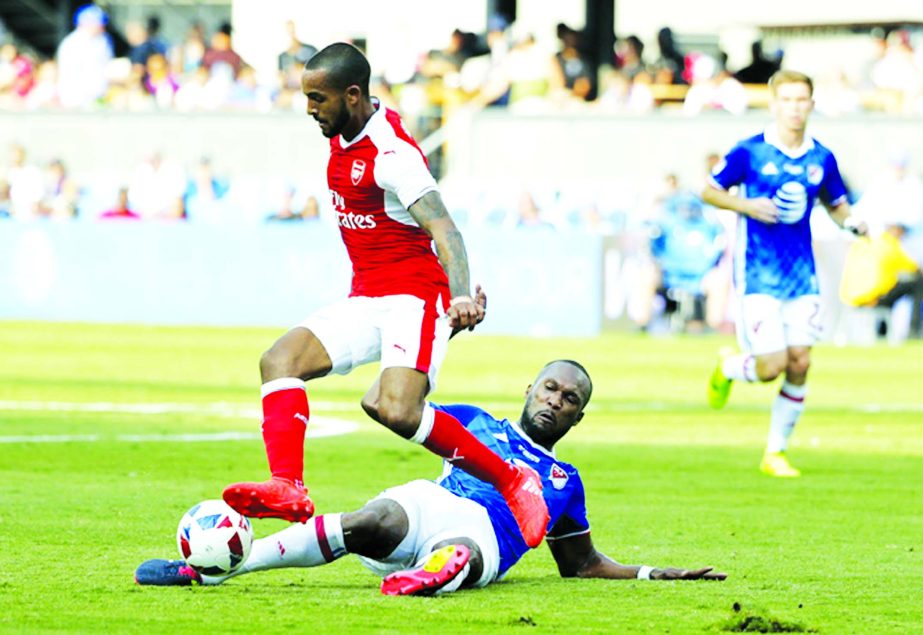 MLS All-Stars' Kendall Waston (bottom) of the Vancouver Whitecaps makes a slide tackle under Arsenal's Theo Walcott during the second half of the MLS All-Star soccer game on Thursday.