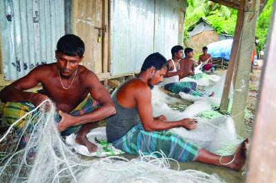 PATUAKHALI: Fishermen in Ghatdeep are passing busy time in making cotton net. This picture was taken on Friday.