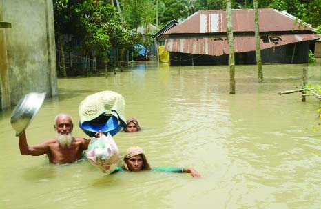 BOGRA: Flood-hit people at Shimulbari area in Dhunot Upazila rushing to take shelter on dam. This picture was taken yesterday.