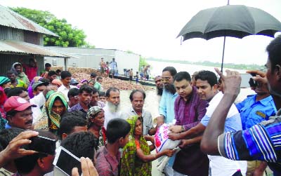 MANIKGANJ: Md Sharifur Rahman, UNO, Daulatpur Upazila and Md Tojammel Huq, Chairman, Upazila Parishad distributing relief goods among the flood affected people at Gyonpur Charkateli Union recently.