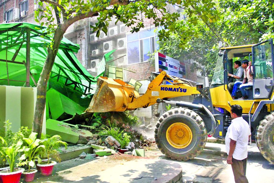 Rajuk authority dismantling unauthorised structures from Dhanmondi area on Sunday.