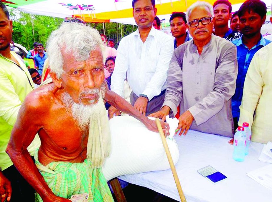 NILPHAMARI: Aftabuddin Sarker MP distributing relief goods among the flood victims in Dimla Upazila on Tuesday.