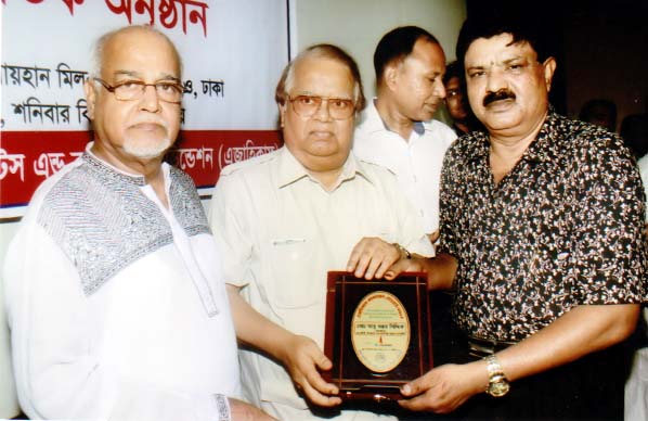 Former minister Barrister Nazmul Huda handing over award to the Chairman of 'Matsyajibi Upajati Hatadaridra Unnayan Society' Abu Bakar Siddique for his contribution in creating employment opportunity for the poor at a ceremony organised recently by Asia