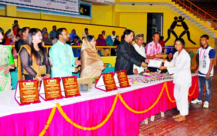 District Governor of Lions Club International MK Bashar distributes prize to a winner of the First National Gensiriu Karate Competition at the Shaheed Suhrawardy Indoor Stadium in Mirpur on Friday.