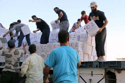 Photo shows Syrians unload boxes after a 48-truck convoy from the ICRC, SARC and UN entered the Syrian rebel-held town of Talbiseh, a besieged area in northern rural Homs