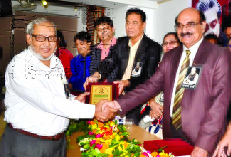 Awami League Advisory Council Member Advocate Yusuf Hossain Humayun handing over award to the Principal of Government Bangla College, Mirpur, Dhaka Prof Imam Hossain for his contribution in education at a programme organised by 71 Media Vision in Prof Akh