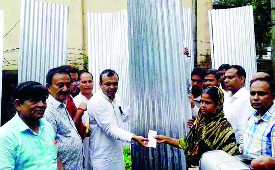 BARISAL; Golum Faruk, Chairman, Banaripara Upazila distributing relief materials among the flood victims at Banaripara on Tuesday.