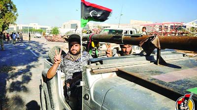 Libyan forces signalling victory sign after capturing ISIL headquarters in Sirte.