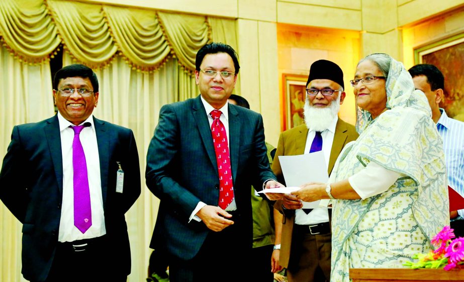 Chairman of City Bank Rubel Aziz handed over a cheque of Tk.7.5 million to Prime Minister Sheikh Hasina as contribution to the Prime Minister's Relief Fund for flood affected victims at Gonobhabon on Tuesday. Sohail R. K. Hussain, Managing Director & CEO
