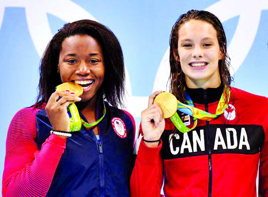 Canada's Penny Oleksiak (right) and United States' Simone Manuel celebrate their tie for gold in the women's 100-meter freestyle at the Summer Olympics in Rio de Janeiro, Brazil on Friday.