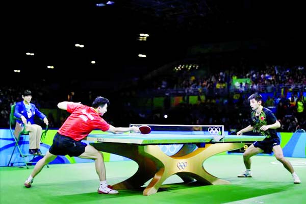 Ma Long of China (left) returns a shot to Zhang Jike of China during the men's table tennis gold medal match at the 2016 Summer Olympics in Rio de Janeiro, Brazil on Thursday.