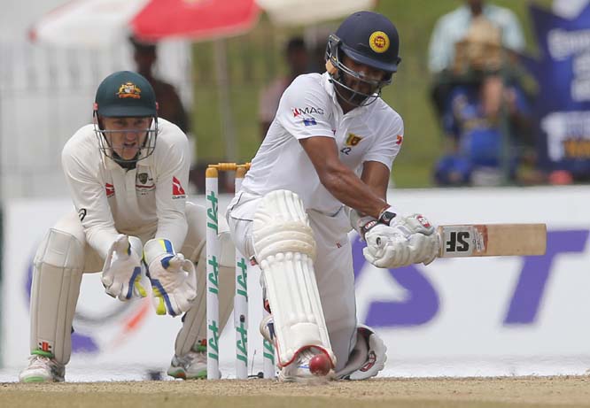Sri Lanka's Dinesh Chandimal plays a shot as Australia's Peter Nevill watches on the day two of their third Test cricket match in Colombo, Sri Lanka on Sunday.