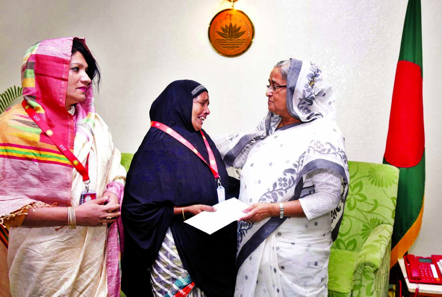 Prime Minister Sheikh Hasina handing over a cheque to the mother of former Chhatra League leader of Satkania Azizul Hakim Toukir who was killed in terrorist attack on August 14, 2014 at her office yesterday.