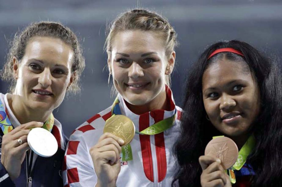 Gold medal winner Croatia's Sandra Perkovic, center, silver medal winner France's Melina Robert-Michon, left, and bronze medal winner Cuba's Denia Caballero after the award ceremony for the women's discus throw during the athletics competitions of the