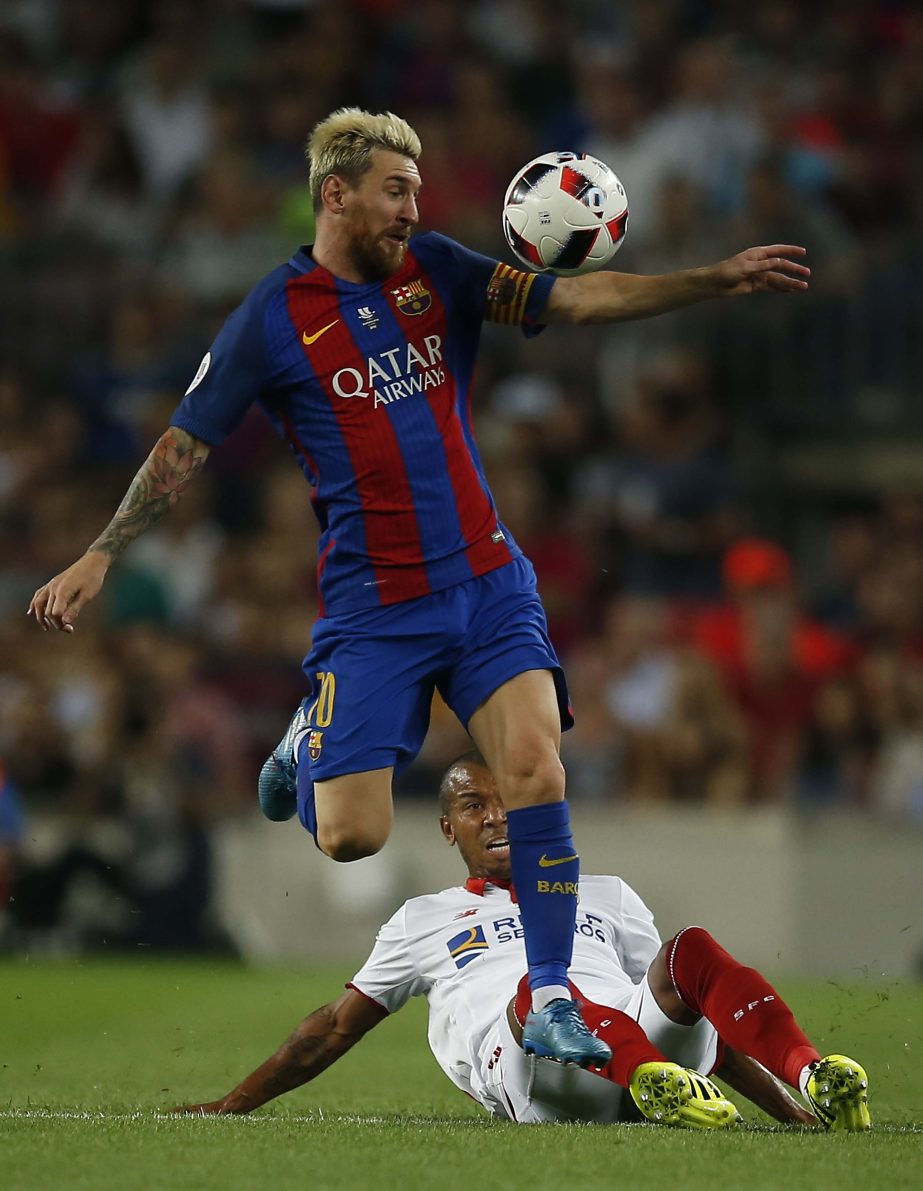 FC Barcelona's Lionel Messi (top) duels for the ball against Sevilla's Mariano during the Spanish Super Cup final soccer match between FC Barcelona and Sevilla at the Camp Nou in Barcelona, Spain on Wednesday.