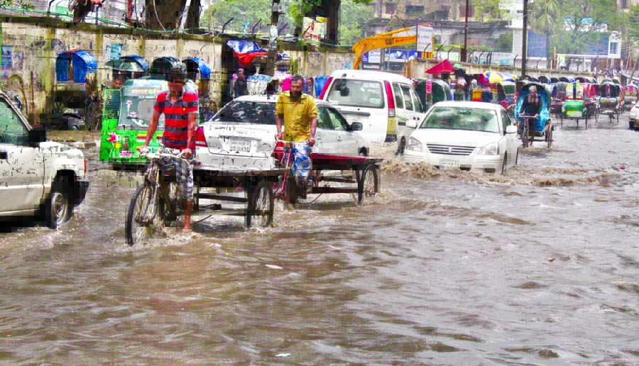 Motorized vehicles and rickshaws struggle through stagnated rain water in front of the Amar Ekushey Hall of Dhaka University on Sunday. The situation remains the same for long due to absence of proper drainage system but the authority concerned seemed to