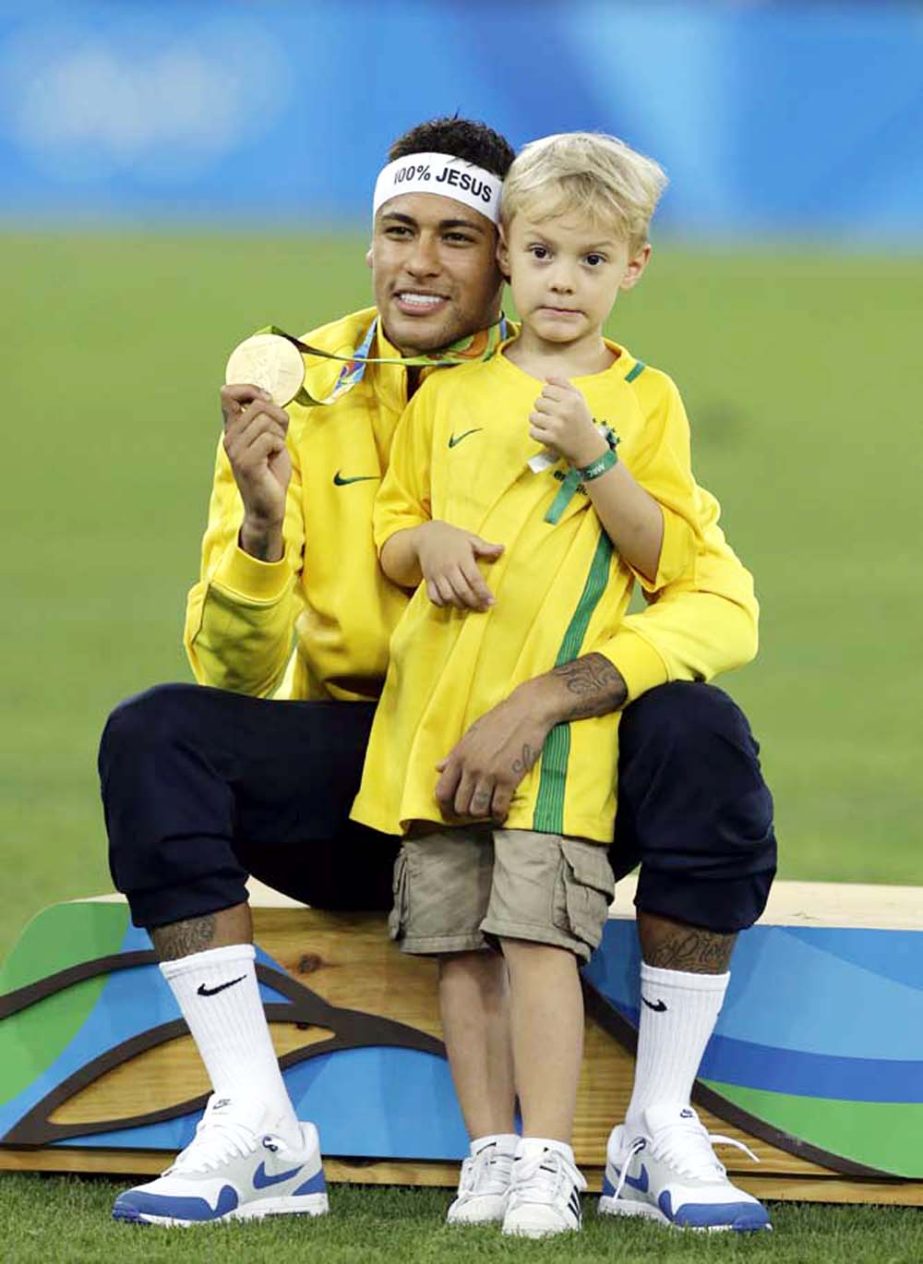 Brazil's Neymar poses with his son Davi Lucca after the medal ceremony of the final match of the mens's Olympic football tournament between Brazil and Germany at the Maracana stadium in Rio de Janeiro, Brazil, Saturday. Brazil won the gold medal on pena