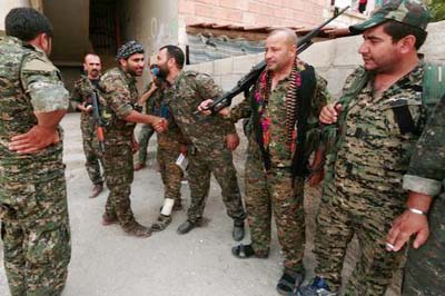 Kurdish fighters from the People's Protection Units (YPG) greet each other in the northeastern city of Hasaka, Syria.