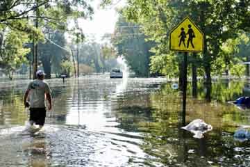 Lester Duplessis walks down a flooded street to his house on August 16 in Gonzales, Louisiana.