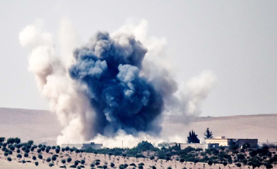 An air strike by a Turkish jet fighter hits the Syrian-Turkish border village of Jarabulus during fighting against IS on Wednesday.
