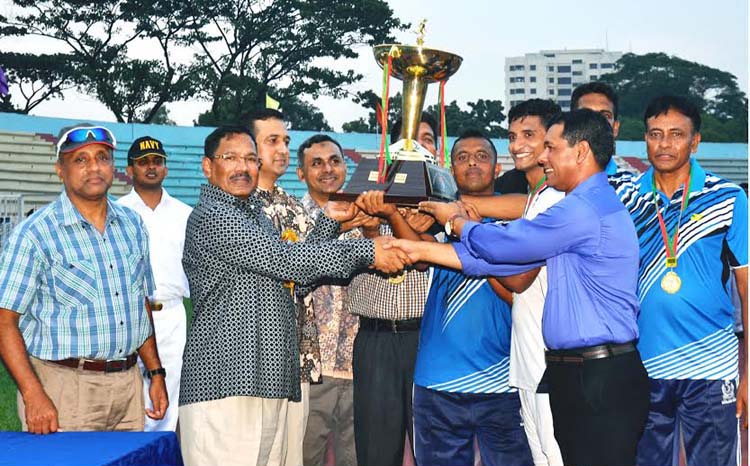 Commandant of Armed Forces Medical College Major General Md Fasiur Rahman handing over the trophy to Bangladesh Navy team, which emerged as the champions of the Inter-Services Football Competition at the Dhaka Army Stadium on Wednesday.